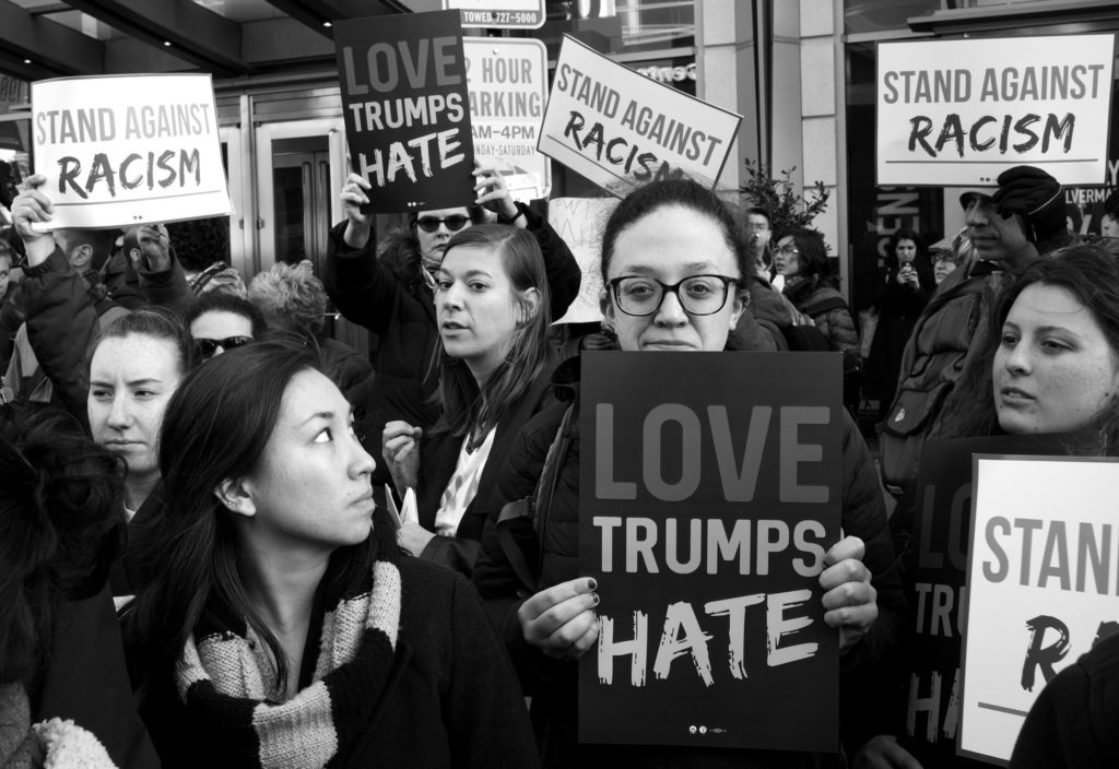 Protesters hold signs reading "Love Trumps Hate" and "Stand Against Racism" during Donald Trump's speech to AIPAC. March 21, 2016. (Flickr / Stephen Melkisethian)