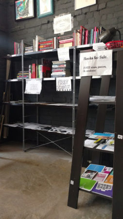 Black Rose Book Distro bookshelves with books, zines, and safer sex supplies