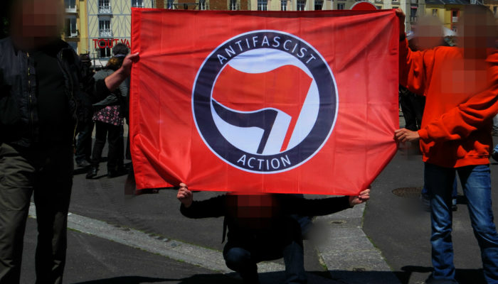 Activists hold an Antifascist Action flag at a rally in France.