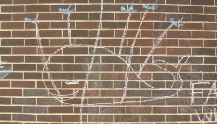 A brick wall with simple chalk drawings of a blue Twitter bird in flight and a "Fail Whale" being held aloft by little birds. Hints of previous, half-erased chalk drawings linger.